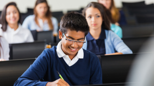 School students in uniform smiling and writing