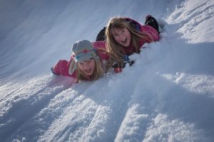 Two children enjoy the winter snow.